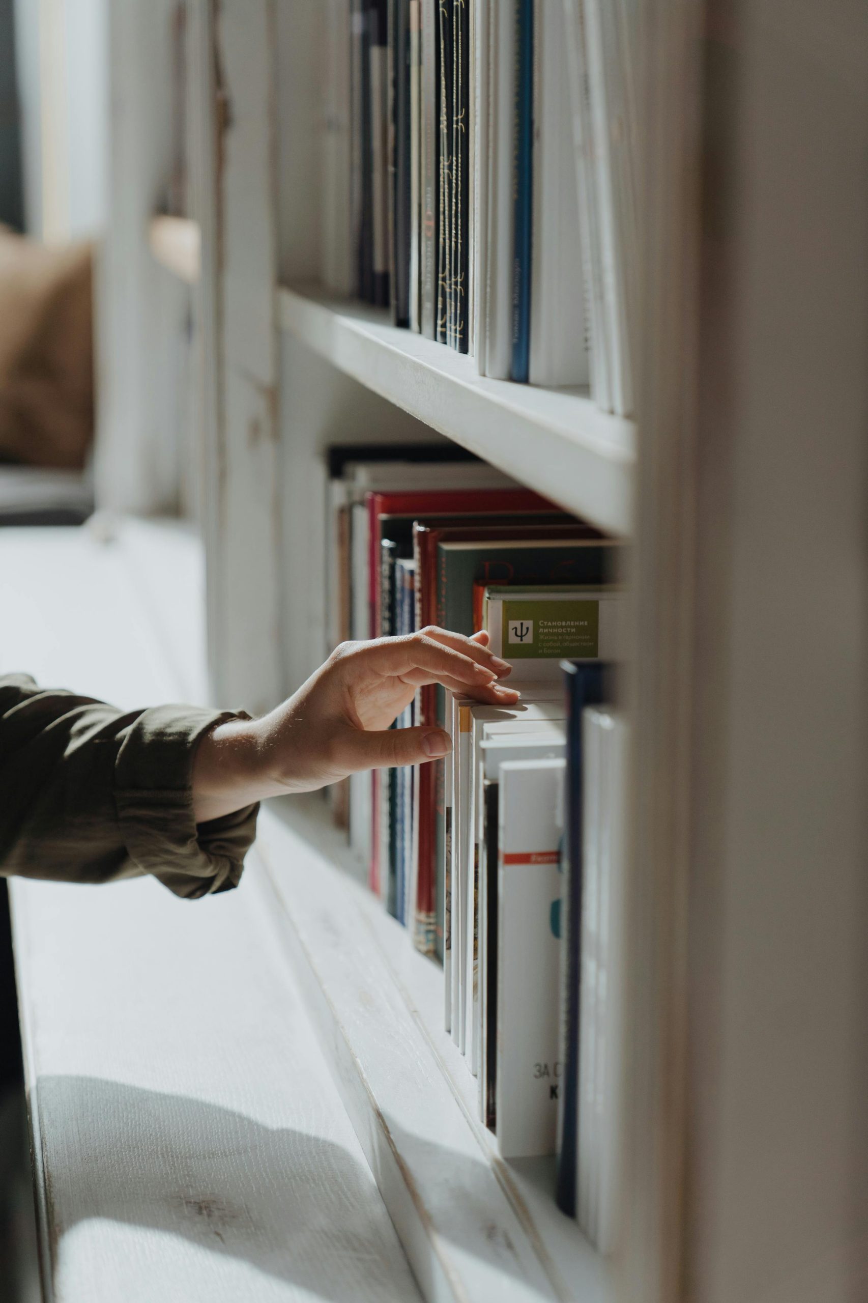 person searching for book in library